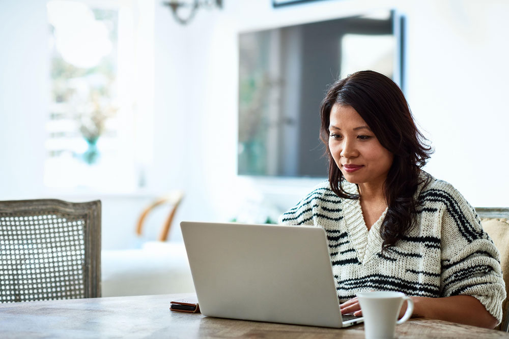 woman sitting at table with laptop open