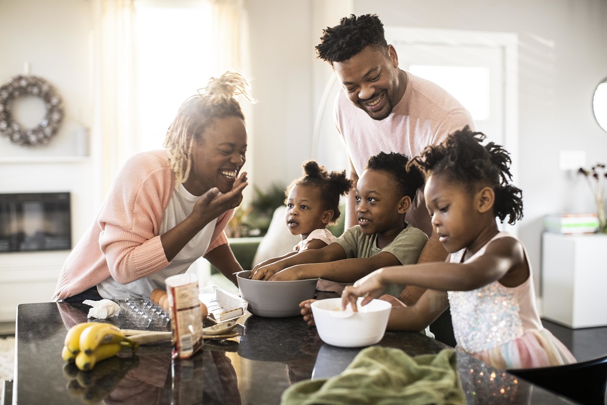 Two parents and three children work together to prepare a healthy meal.