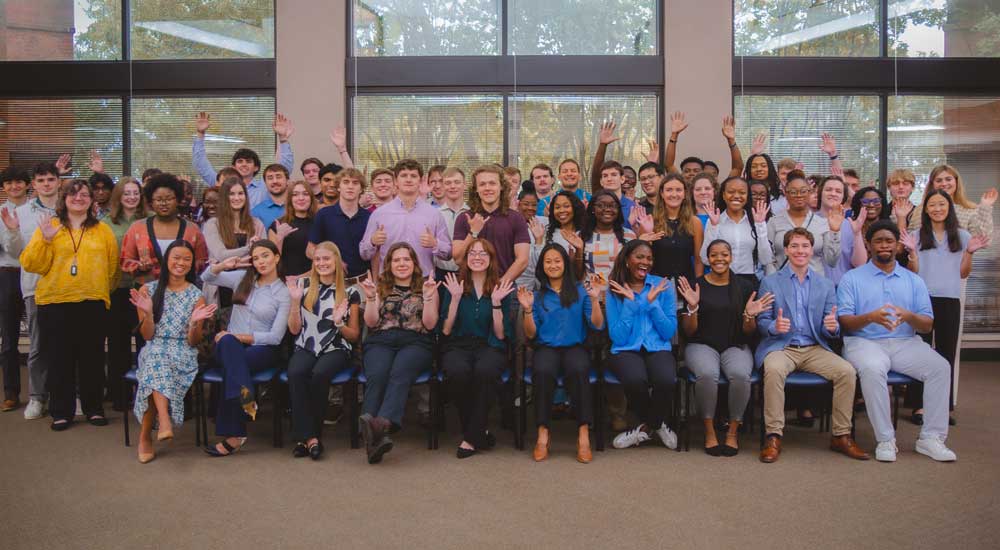 Group of young people waving to camera 